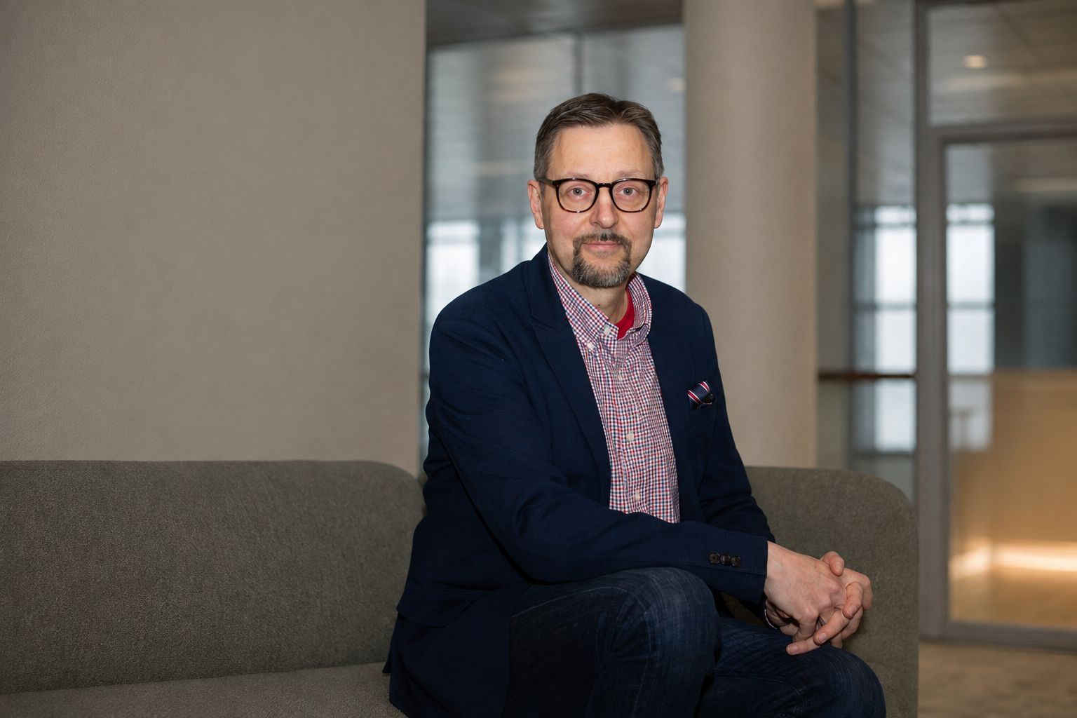 Mika Parikka istumassa modernissa toimistoympäristössä